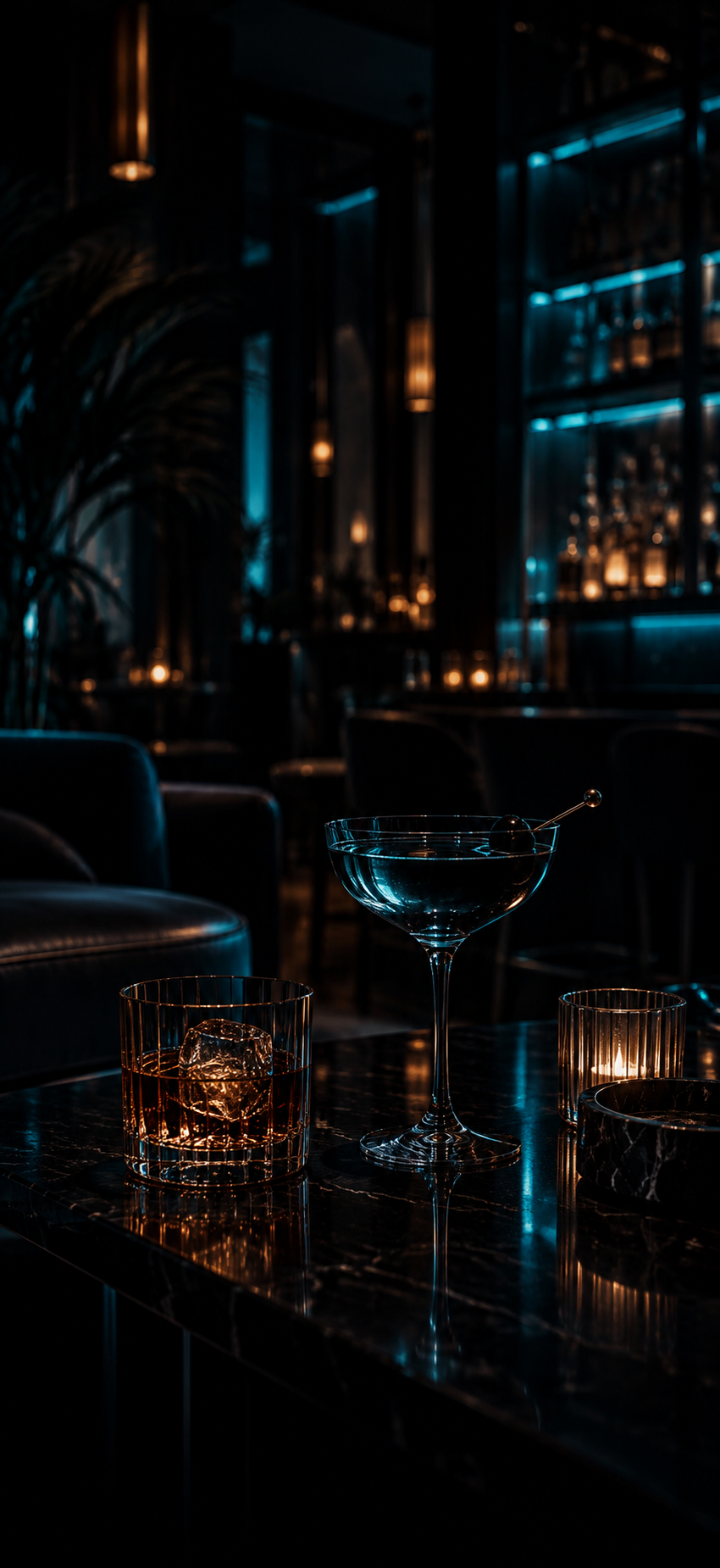 Cocktails on a dark bar table beneath blue ambient light